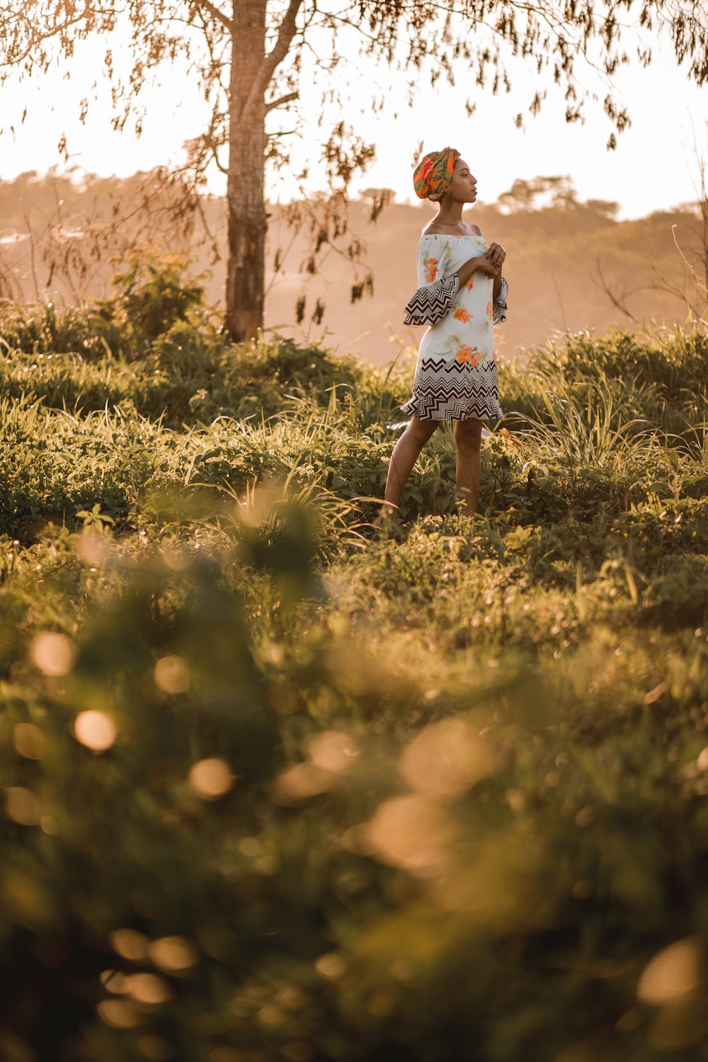 girl in white and black dress standing on green grass field during daytime