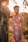 girl in red and white polka dots sleeveless dress standing beside brown tree during daytime