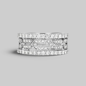 A silver band ring adorned with multiple small, sparkling diamonds arranged in a geometric pattern. The design exhibits a blend of intricate craftsmanship and elegance, featuring two outer rows and an elaborate center section with diamond settings.
