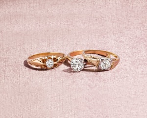silver and diamond ring on white textile