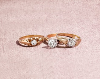 silver and diamond ring on white textile