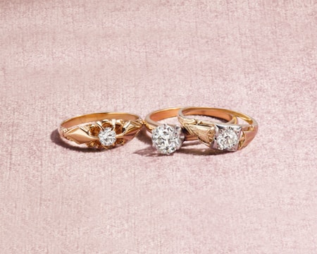 silver and diamond ring on white textile