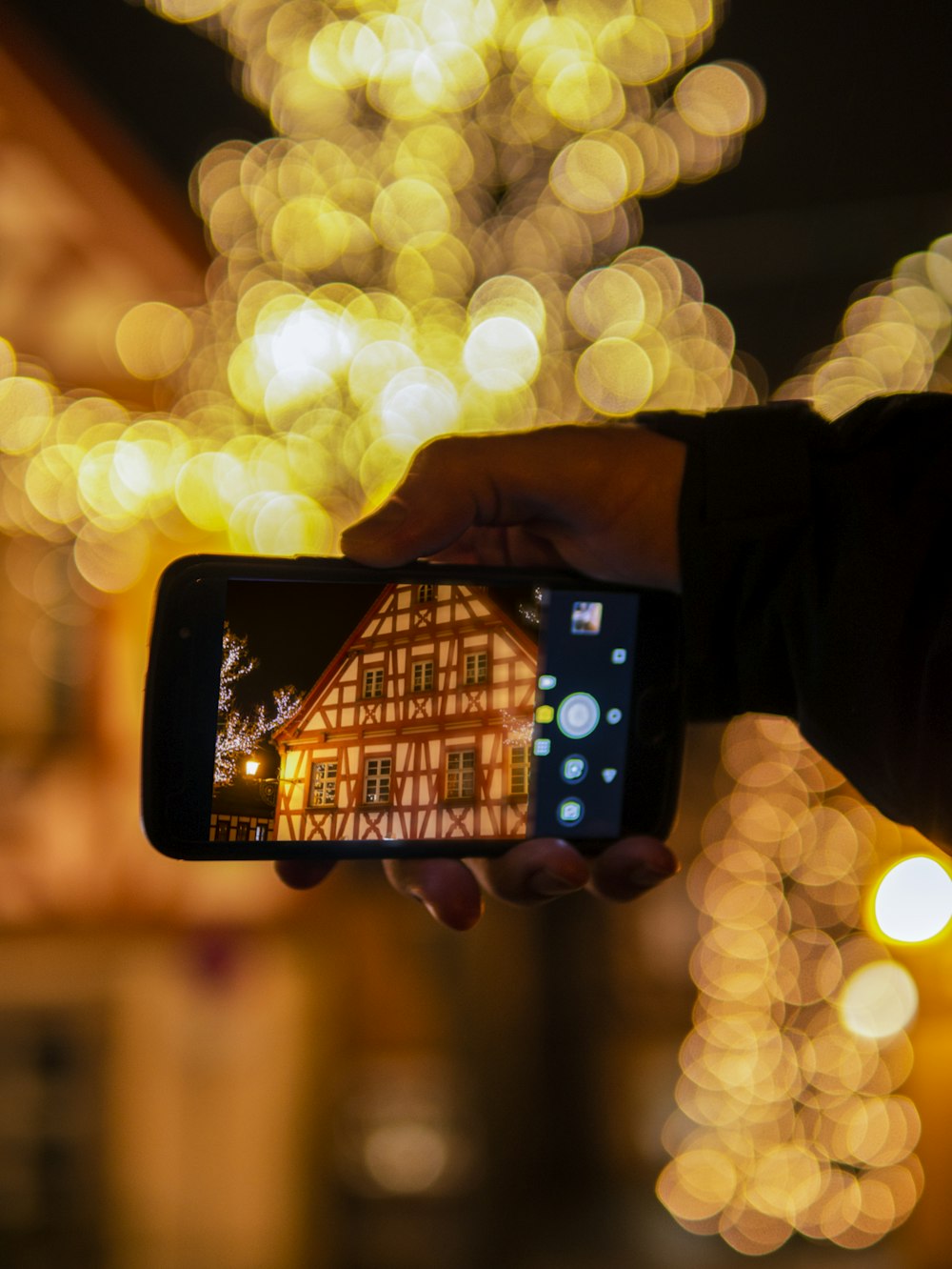person holding black smartphone taking photo of lights
