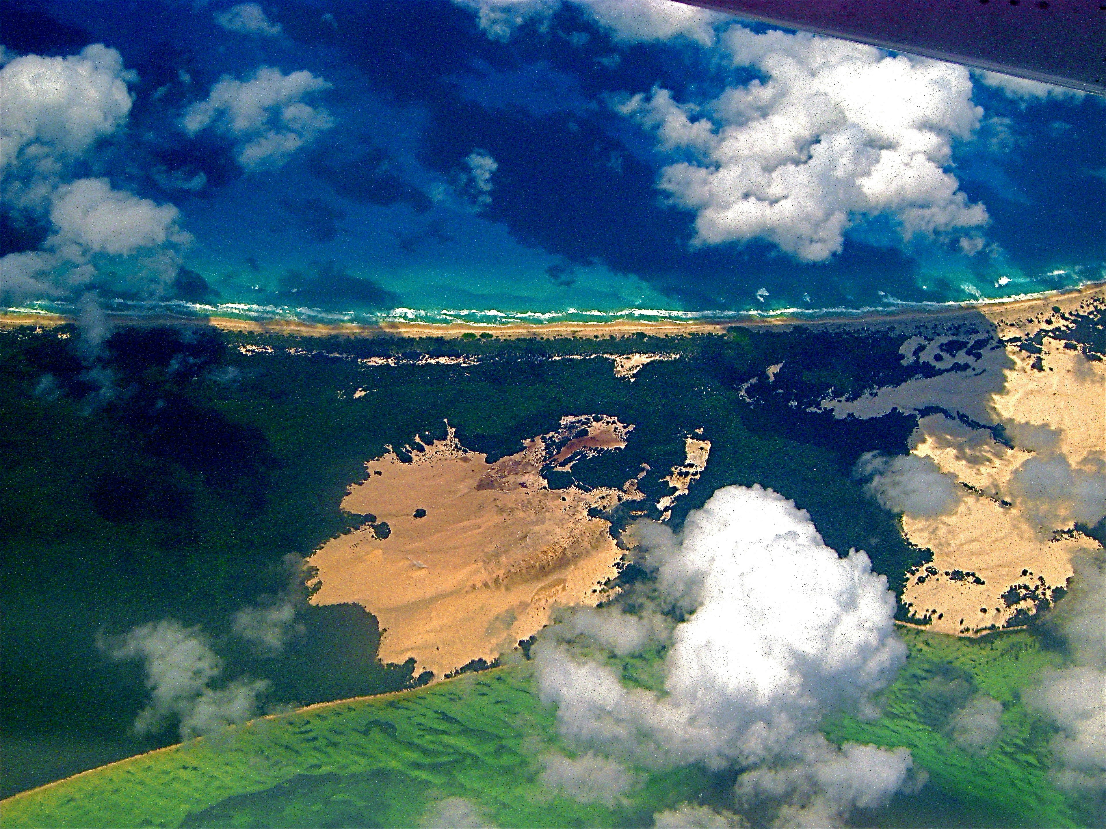 Aerial view of tropical island coastline with turquoise water and lush green vegetation