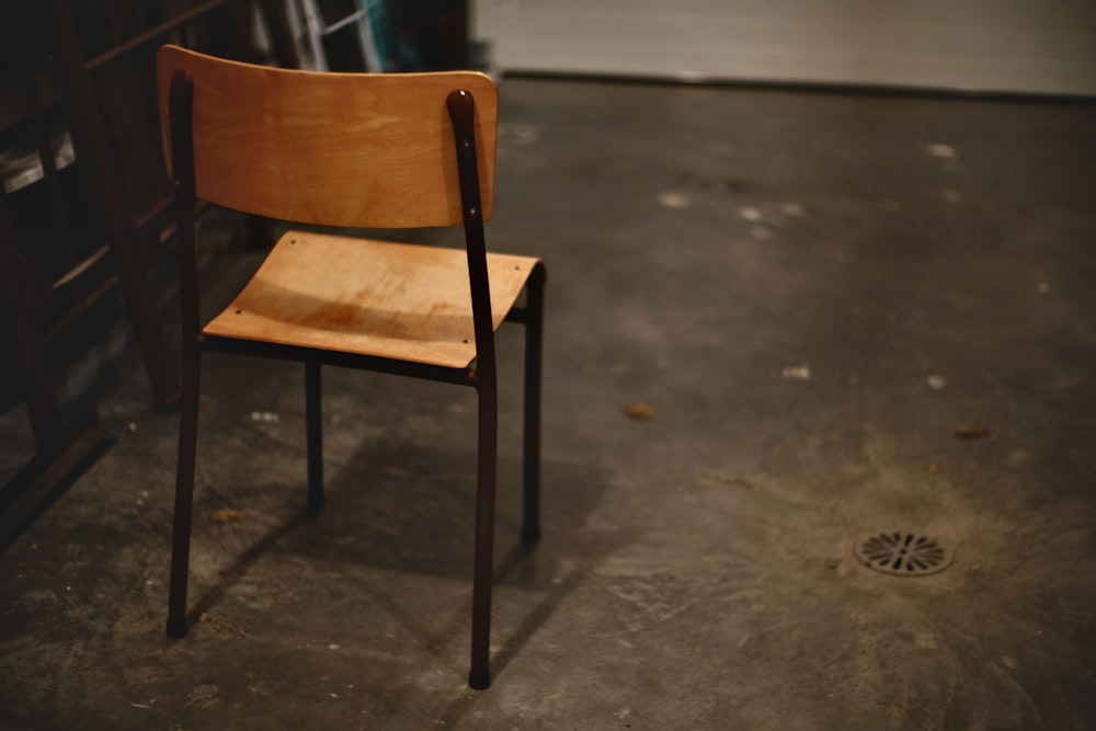 sedia in legno marrone su pavimento in cemento grigio