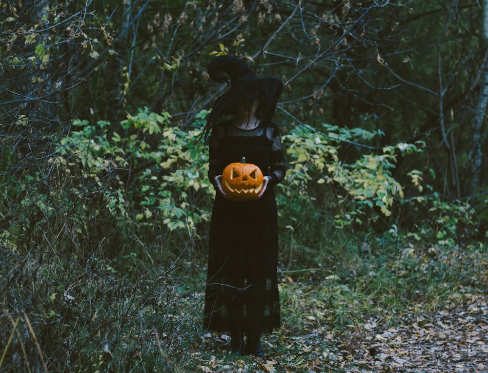 donna in vestito nero in piedi sul campo di erba verde