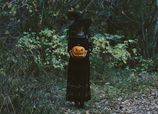 woman in black dress standing on green grass field