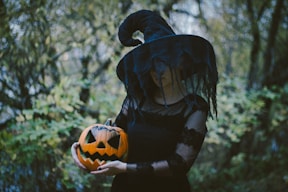 person in black leather jacket holding orange and black ball