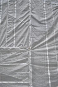 Close-up of durable tarp material stretched tight over a flatbed truck, showing texture and reinforced edges.