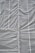 A large sheet of gray construction tarp with vertical and horizontal seams is stretched across the surface. The material appears to have a grid-like texture, with visible creases and folds.
