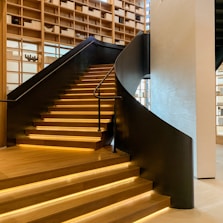 Modern wooden staircase with warm lighting inside a cozy home.