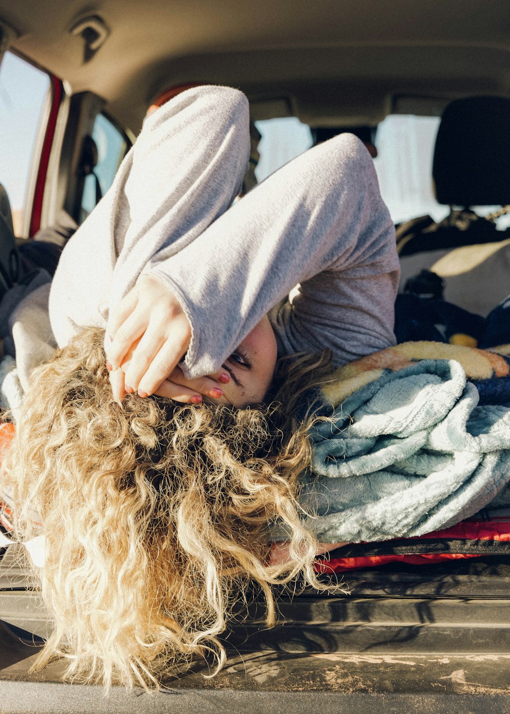 woman in gray long sleeve shirt sitting on bed