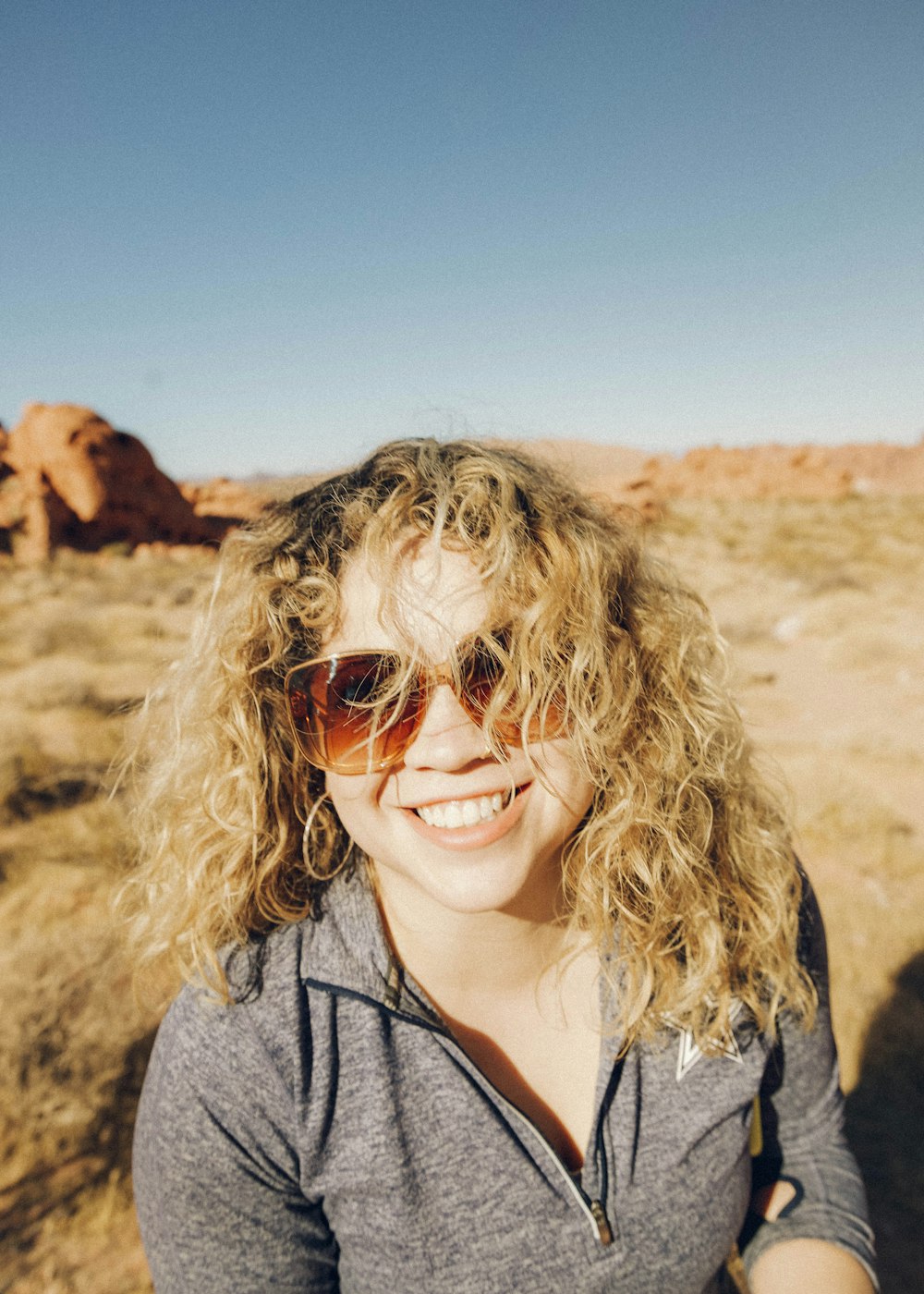 woman in gray hoodie wearing sunglasses