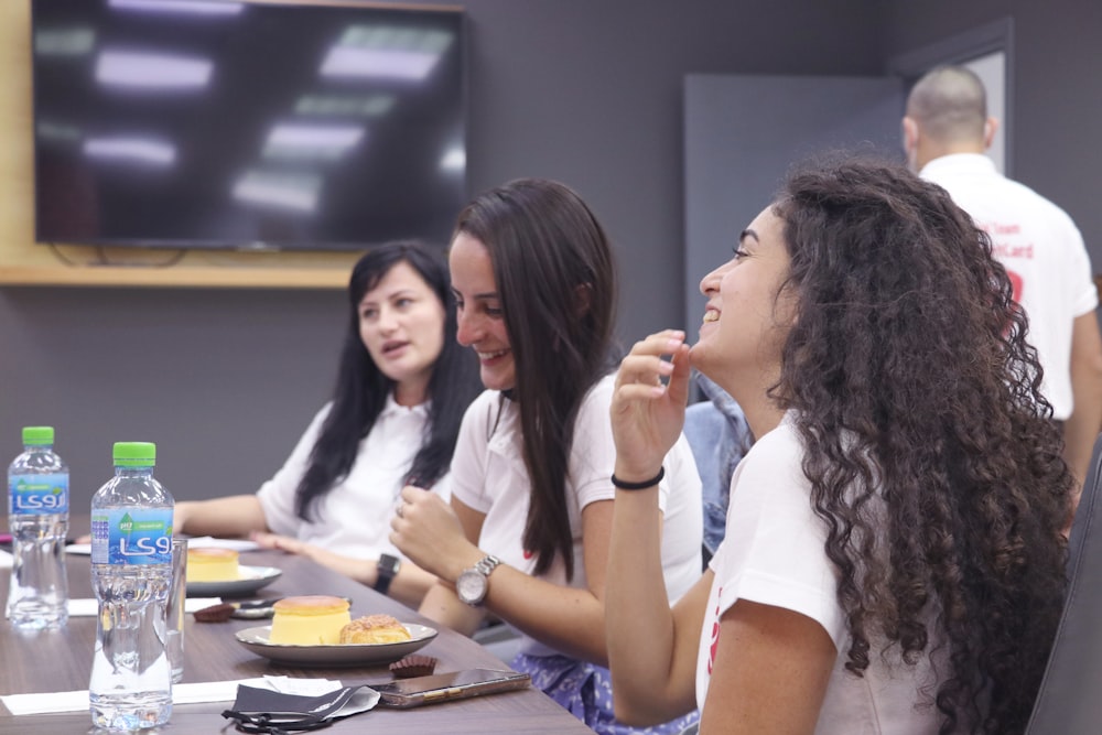 woman in white shirt sitting beside woman in blue shirt