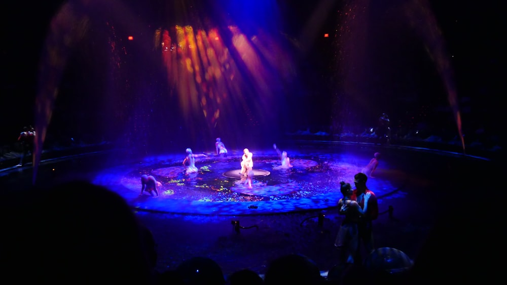 people standing on stage with blue lights