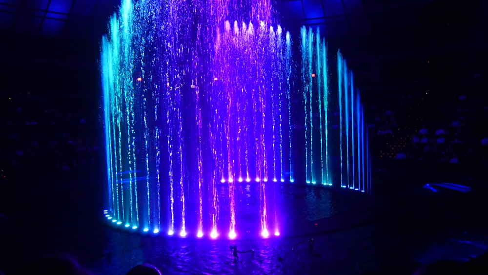 water fountain with lights turned on during night time