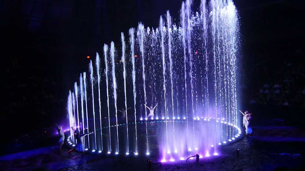 water fountain with lights turned on during night time