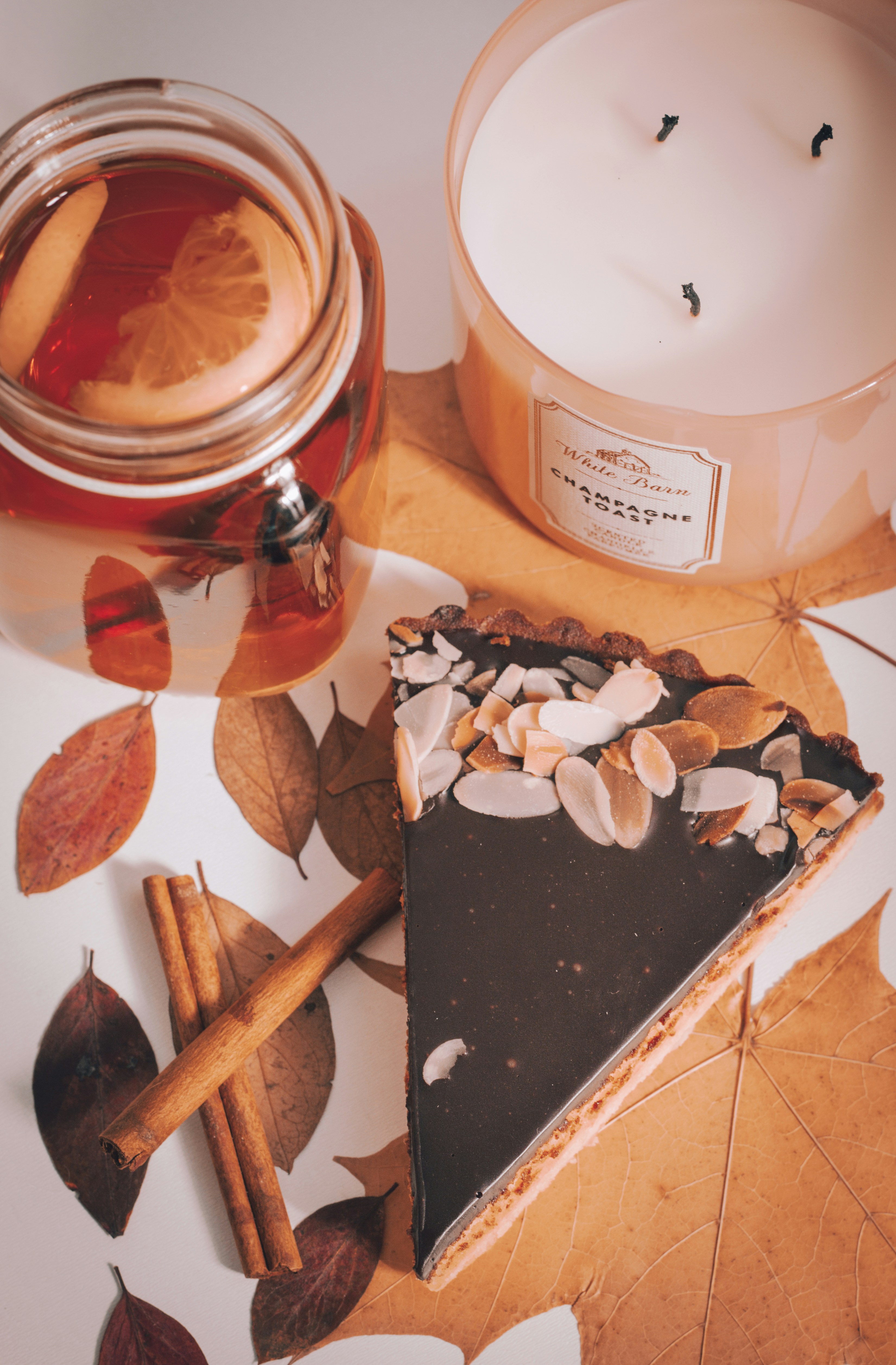 Chocolate cake with autumn leaves on wooden table, warm candlelight, cozy boutique atmosphere