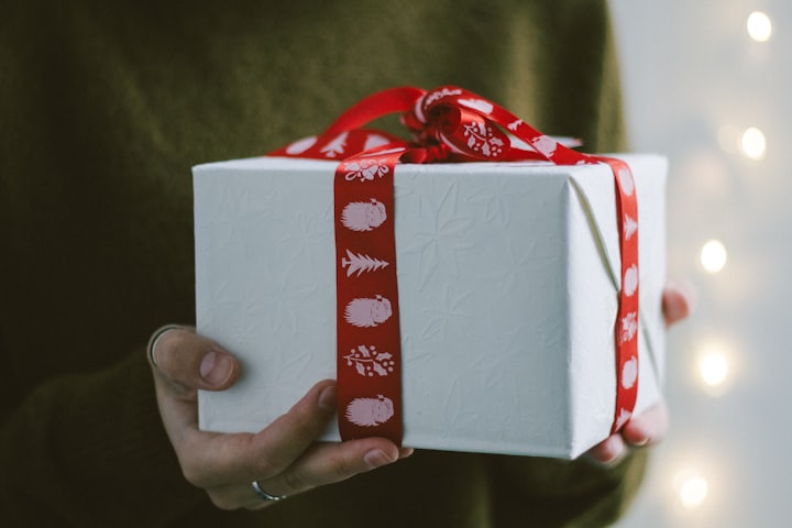 Weißes Geschenk mit rotem Geschenkband