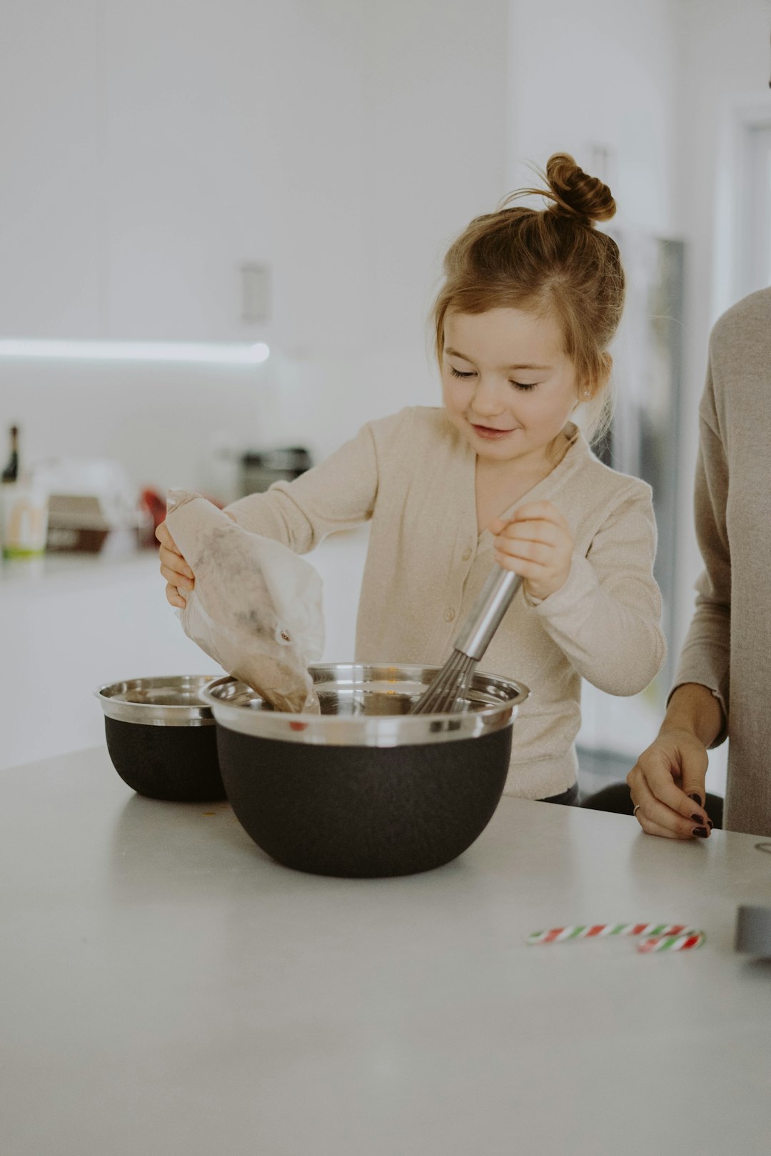 woman in white blazer holding silver spoon and black bowl