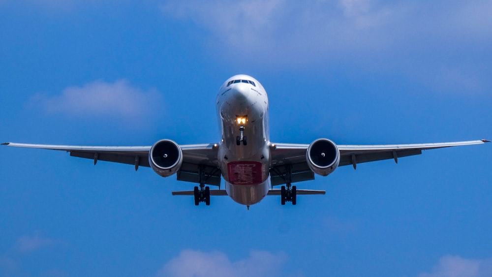 white and blue airplane under blue sky during daytime