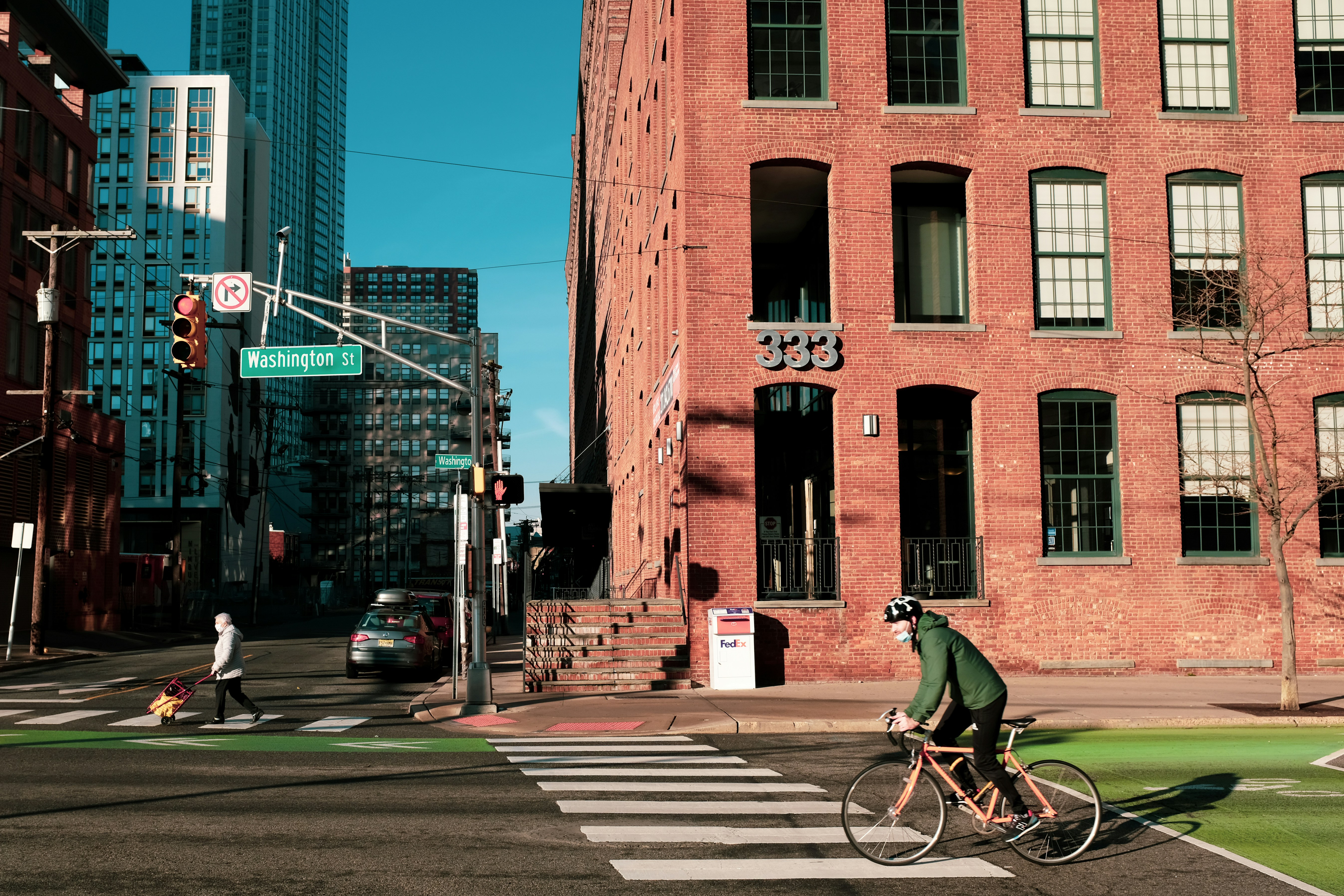 man in green shirt riding bicycle on pedestrian lane during daytime