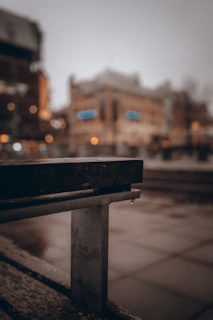 Close-up of a Kunei cap resting on a concrete bench with city streets blurred in the background.