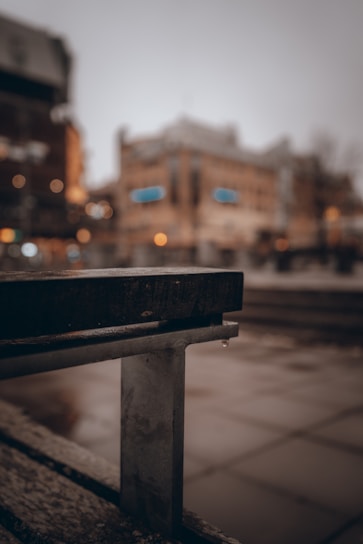 Close-up of a handcrafted urban accessory resting on a city bench with blurred skyline background.