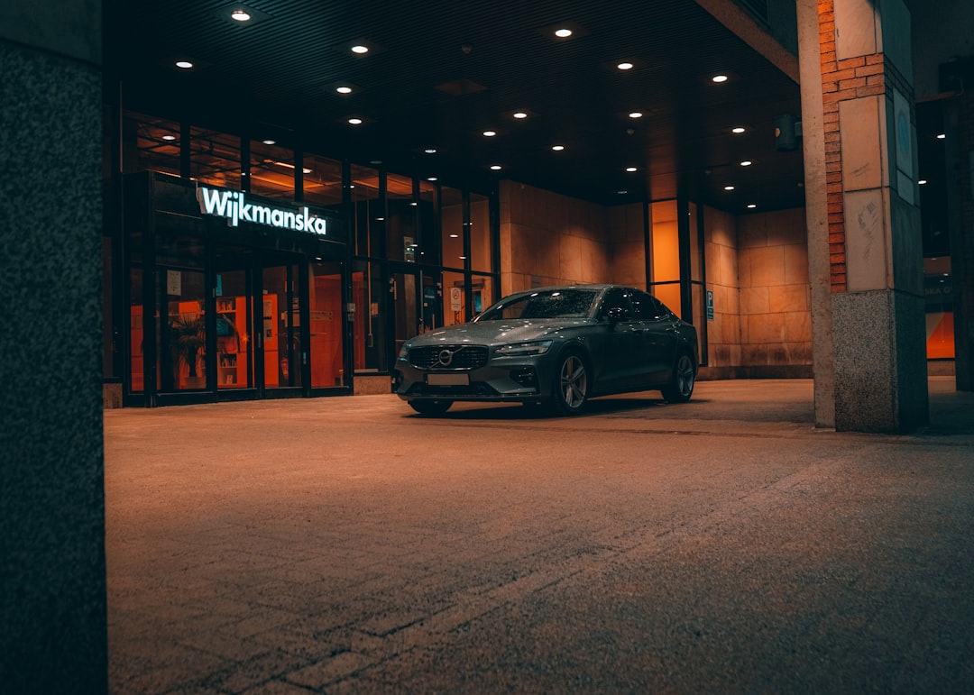 black sedan parked near brown building during night time