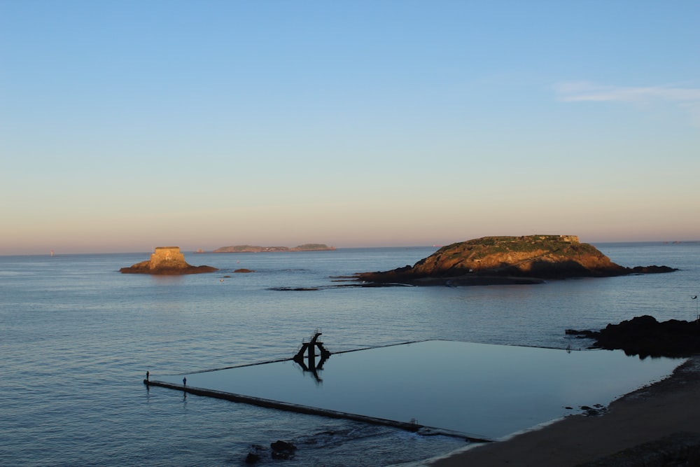 person walking on wooden dock during sunset