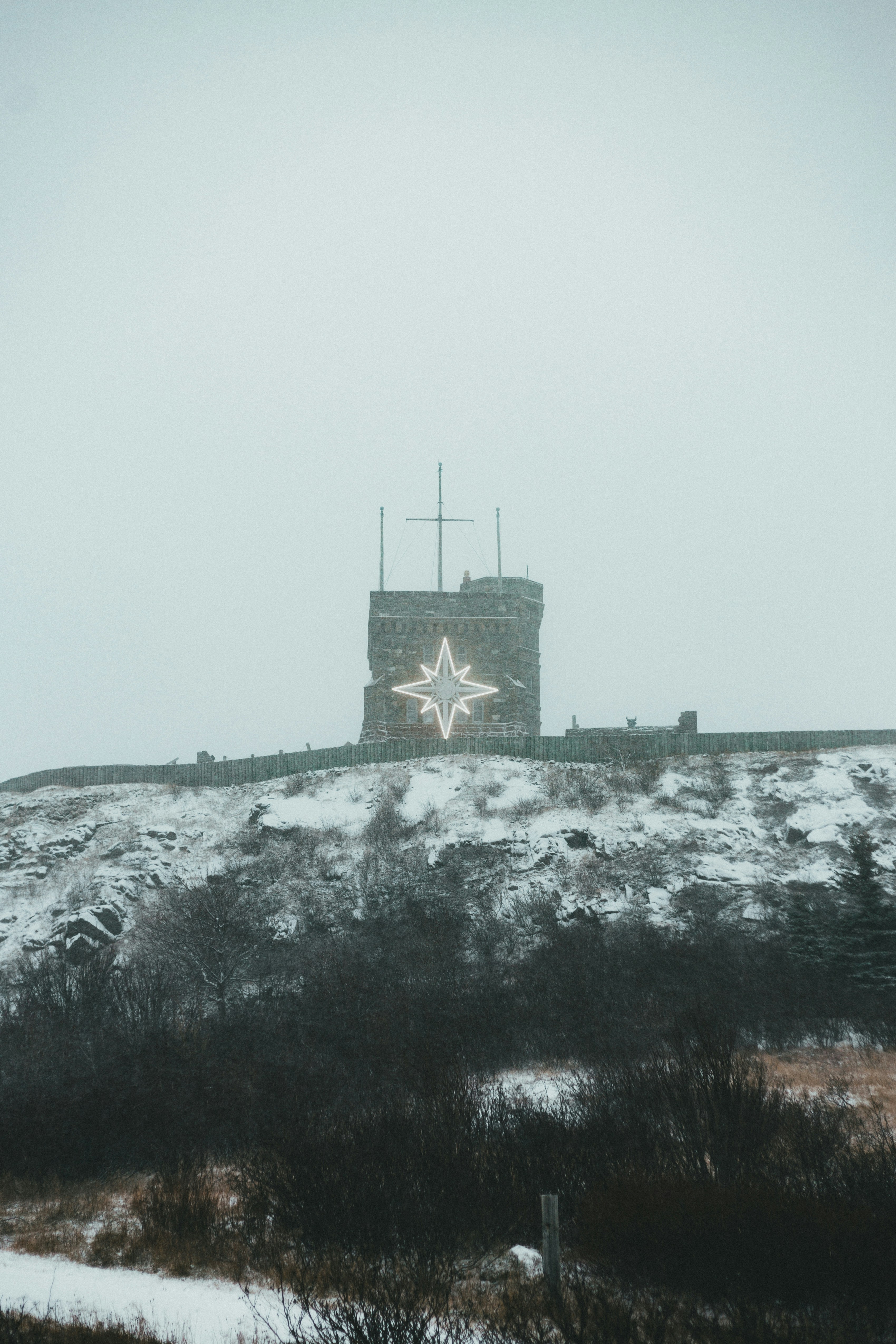 castle on top of hill near body of water