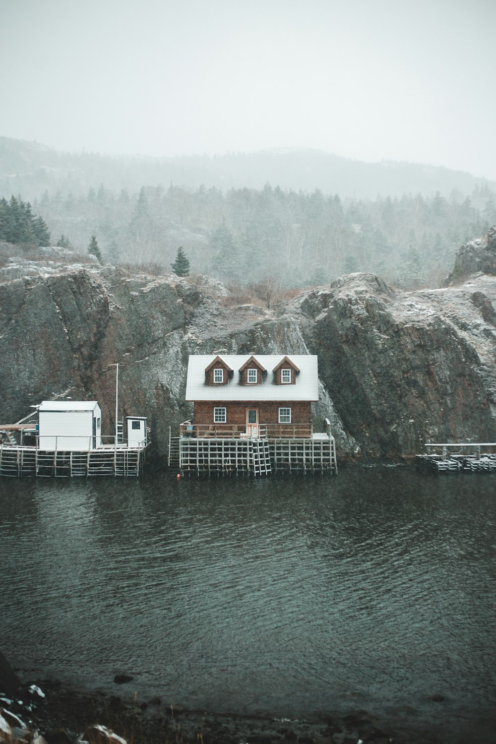 white and brown wooden house near body of water during daytime