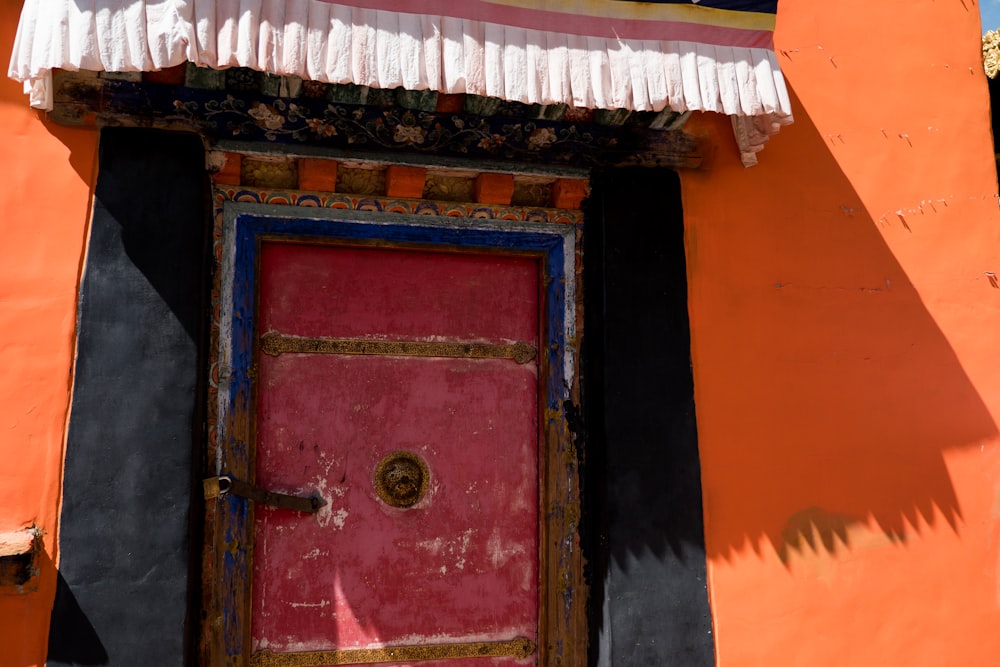 red wooden door with green door knob