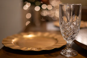 Close-up of delicate glassware catching the light on a wooden table.