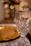 Close-up shot of a beautifully personalized glass with elegant engraving, glowing in warm party lights.
