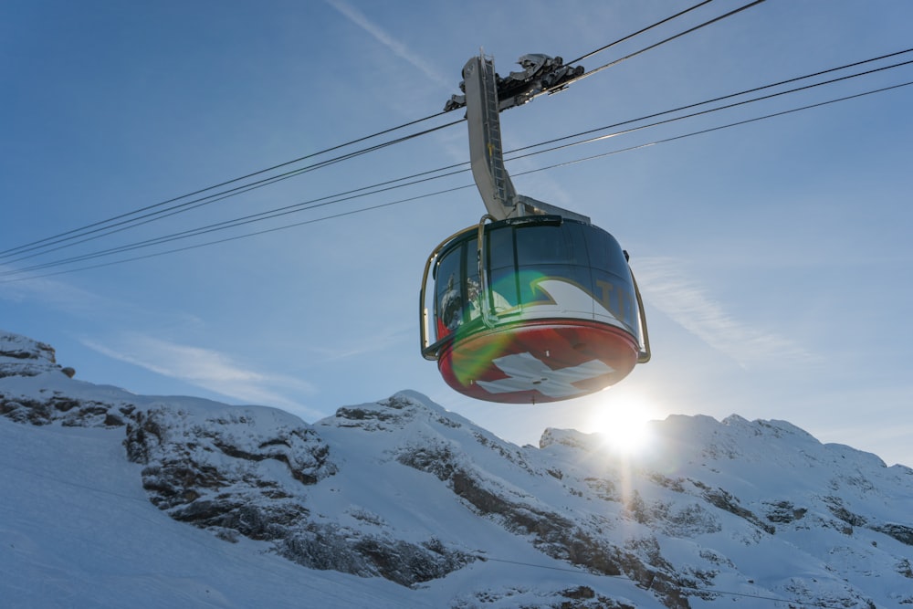 blue and white cable car over snow covered mountain