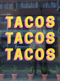a window with a sign that says tacos tacos