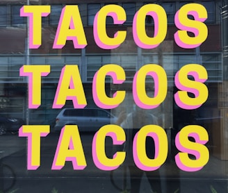 a window with a sign that says tacos tacos