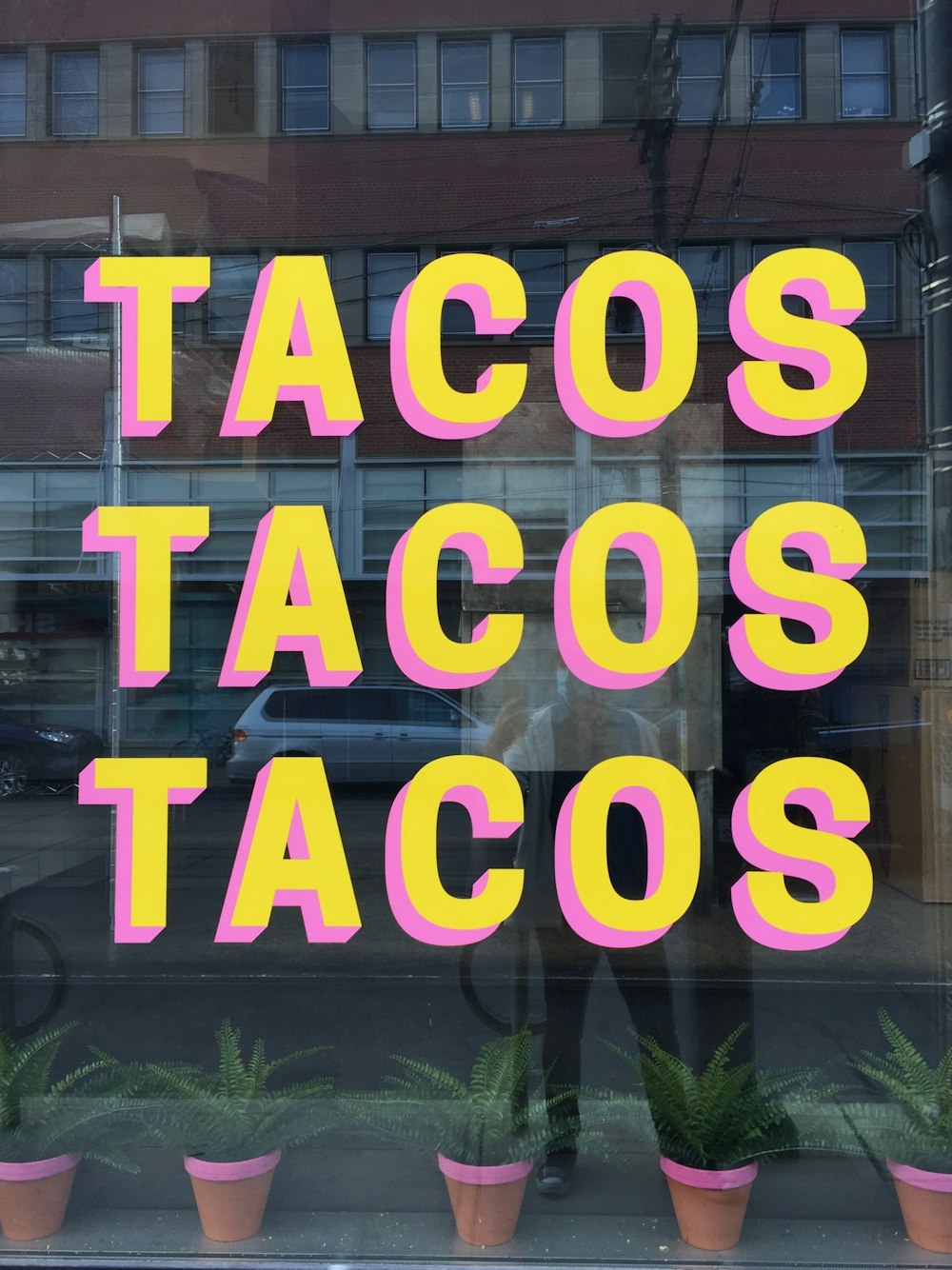 a window with a sign that says tacos tacos