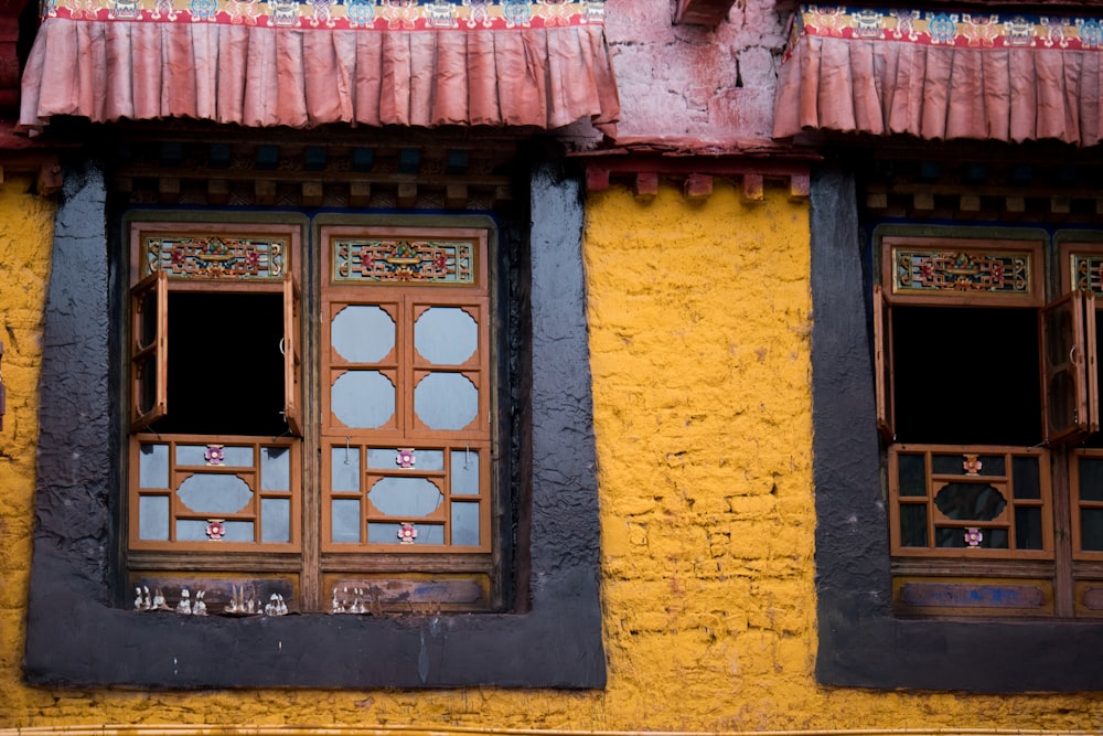 brown wooden window frame on yellow concrete wall