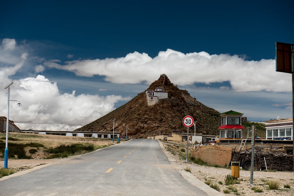 brown and white house near road under blue sky during daytime