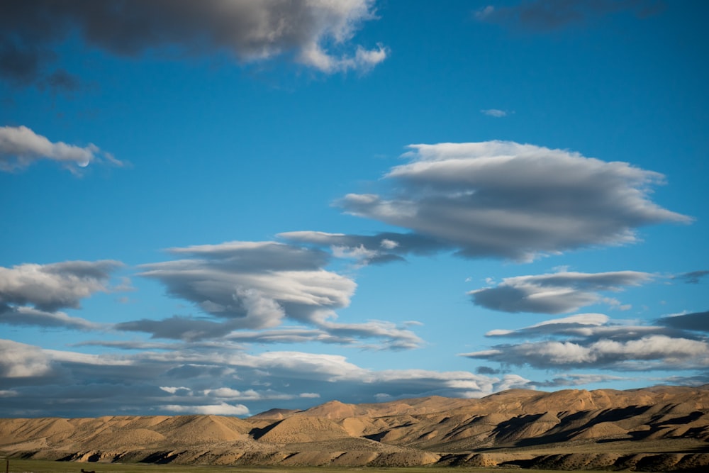 rocky mountain under blue sky and white clouds during daytime