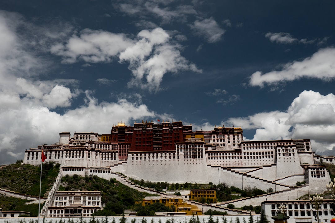 white and brown concrete building under white clouds during daytime