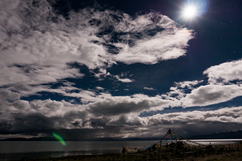 silhouette of wind turbines under cloudy sky during daytime