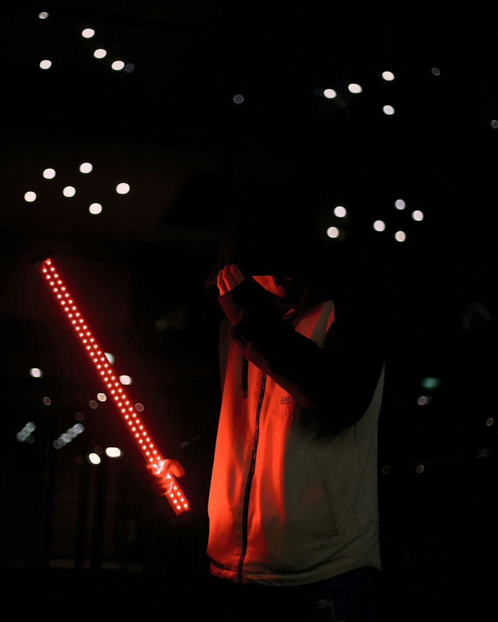 man in white dress shirt holding red light