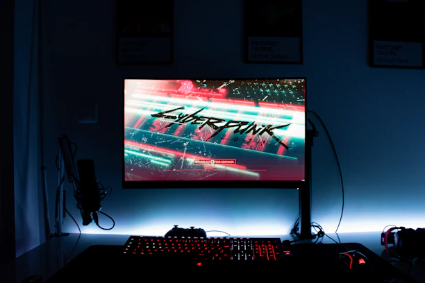 Futuristic gaming setup with neon-lit keyboards and streaming gear glowing in electric blue and purple hues.