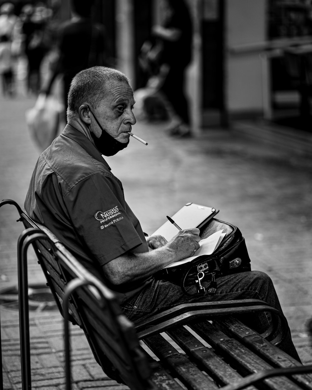 a man sitting on a bench smoking a cigarette