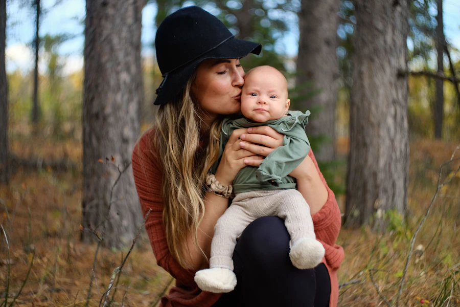A caregiver carrying a baby outdoors, mid-laugh