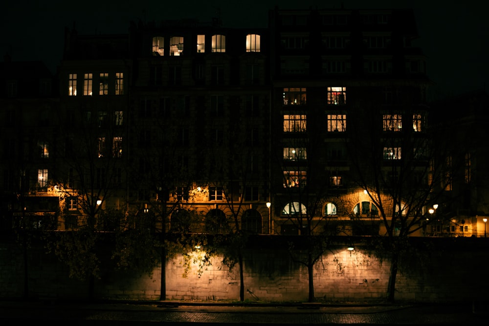 people walking on sidewalk near building during night time