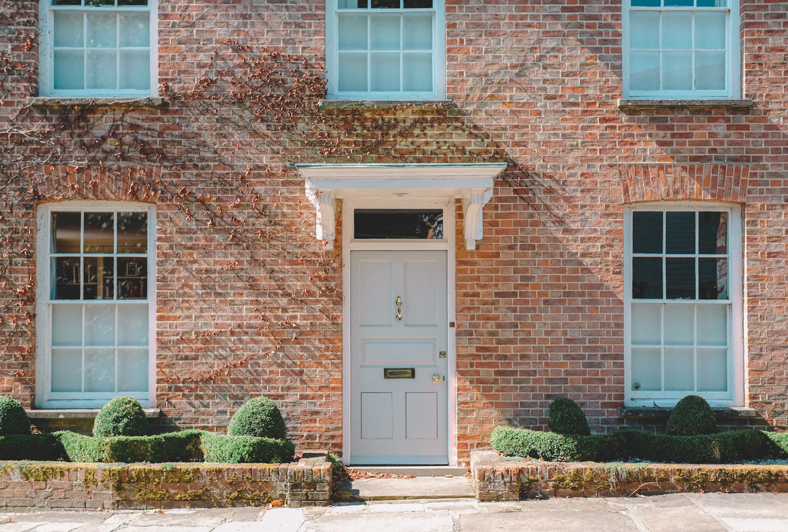 A British brick house frontage with a white wooden door